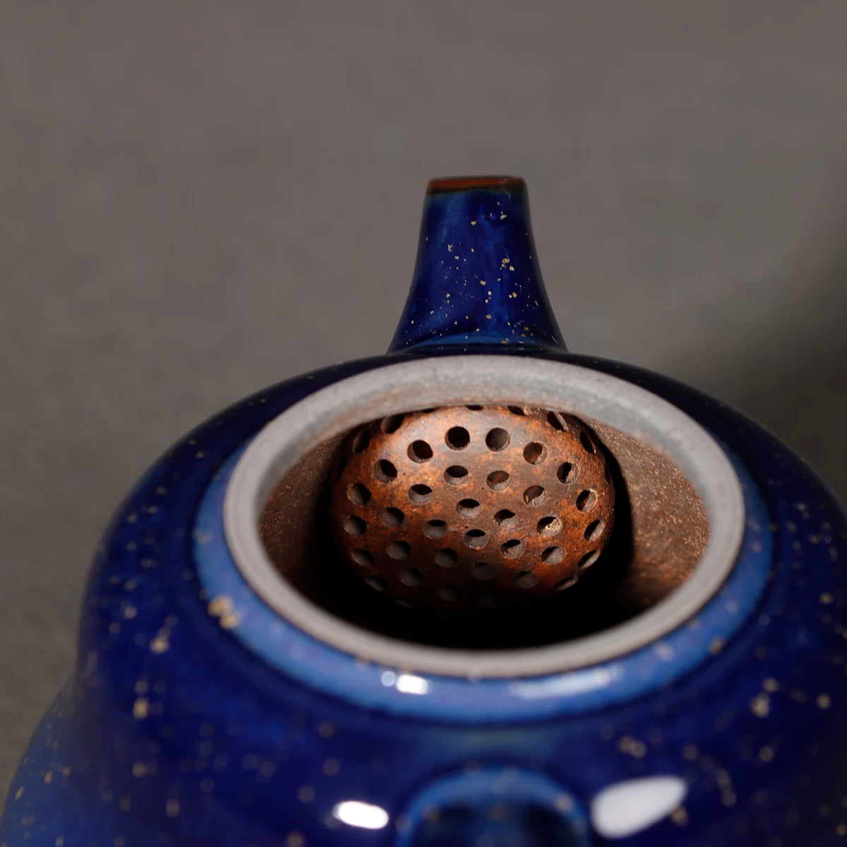 Handmade Jun Ware teapot displaying raw ore starry blue glaze texture and iron rim
