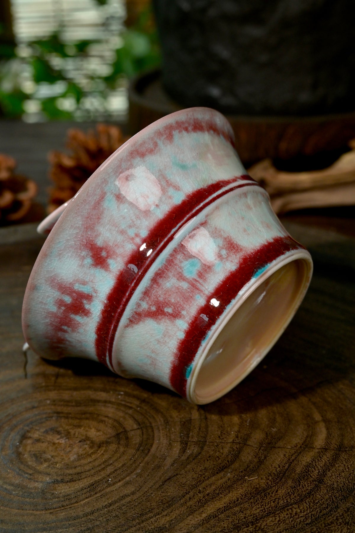 Close-up of flame-red copper glaze and turquoise soda vapor blushing on bamboo Gaiwan lid