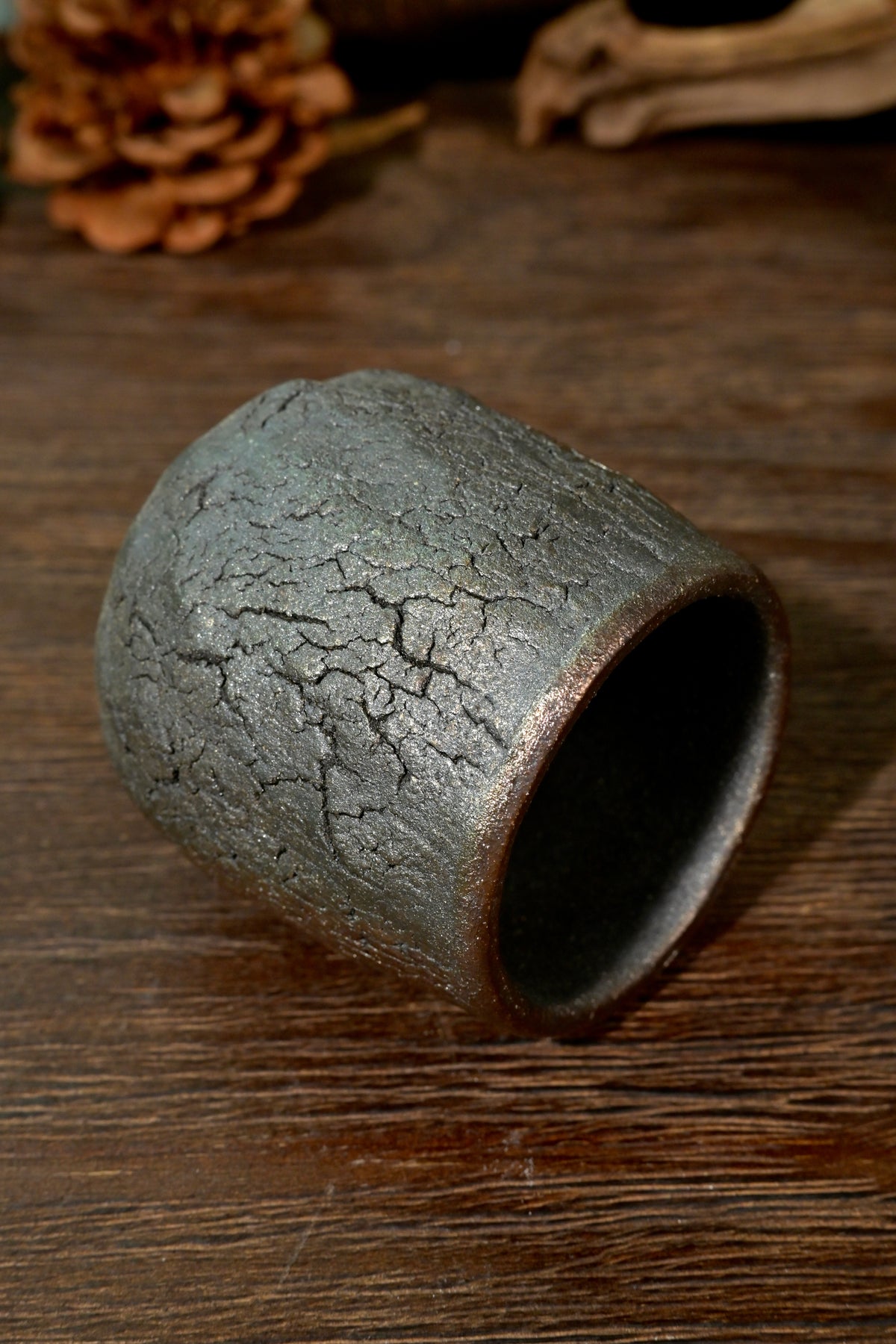 Close-up of metallic bronze ash finish and natural fissures on 1-of-1 wood-fired master teacup