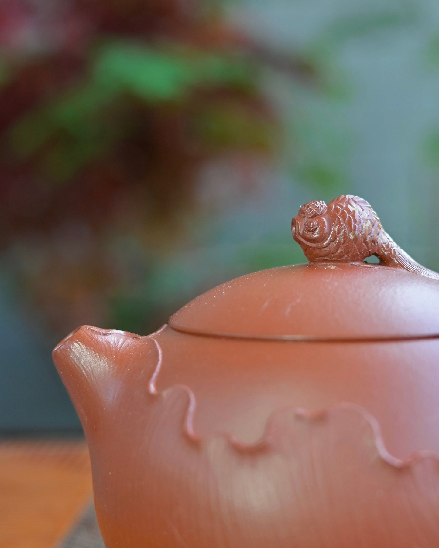 Xishi silhouette teapot with unglazed natural Zhuni surface showing warm reddish-orange color