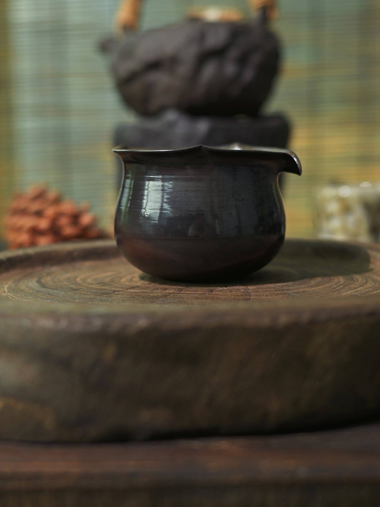 Hand-shaped iron clay fairness cup with a deep metallic luster for professional tea tasting.