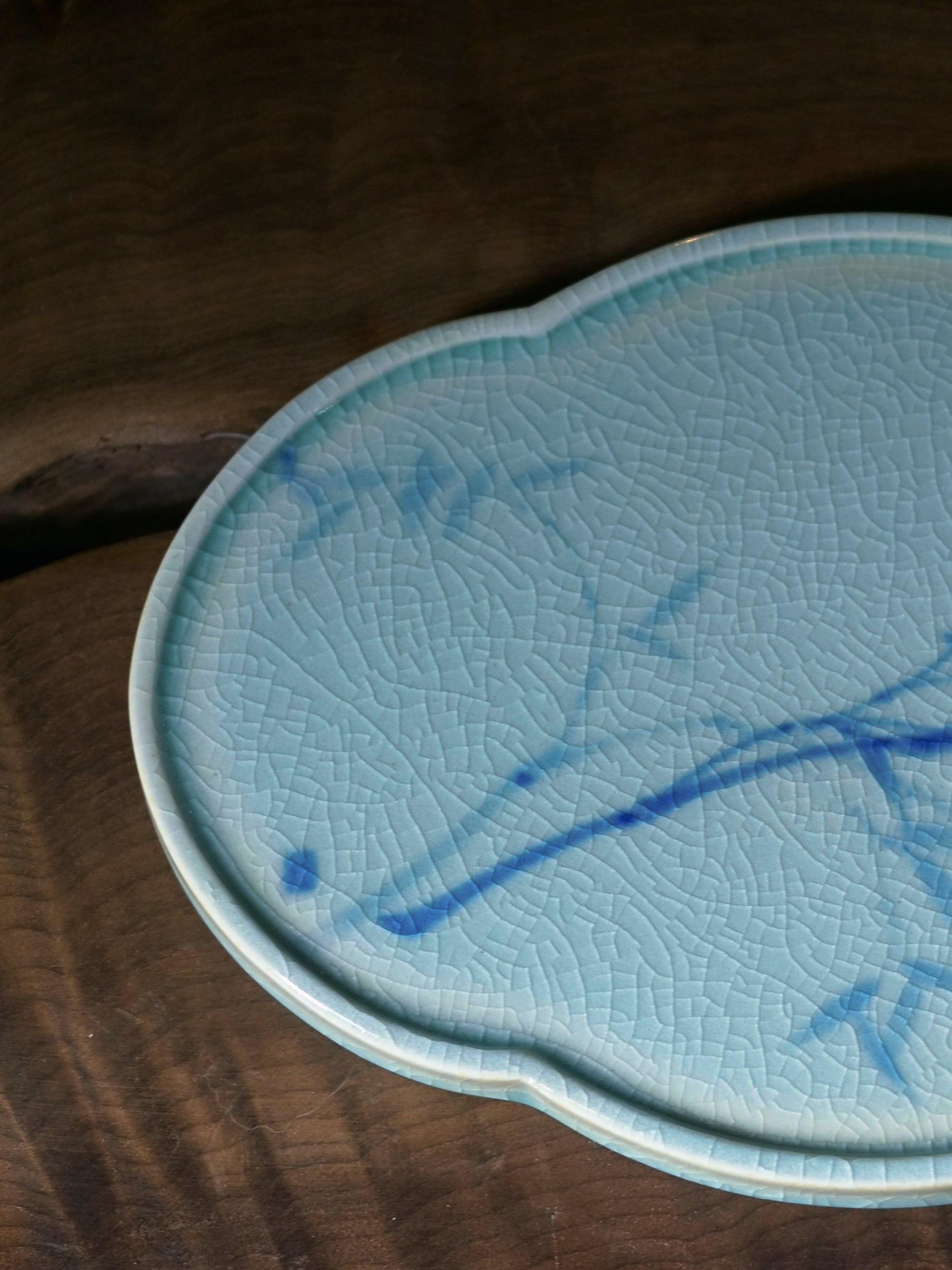 Teapot saucer's surface showing evenly distributed crackles in the glaze, with a subtle blue tint resembling a serene lake.