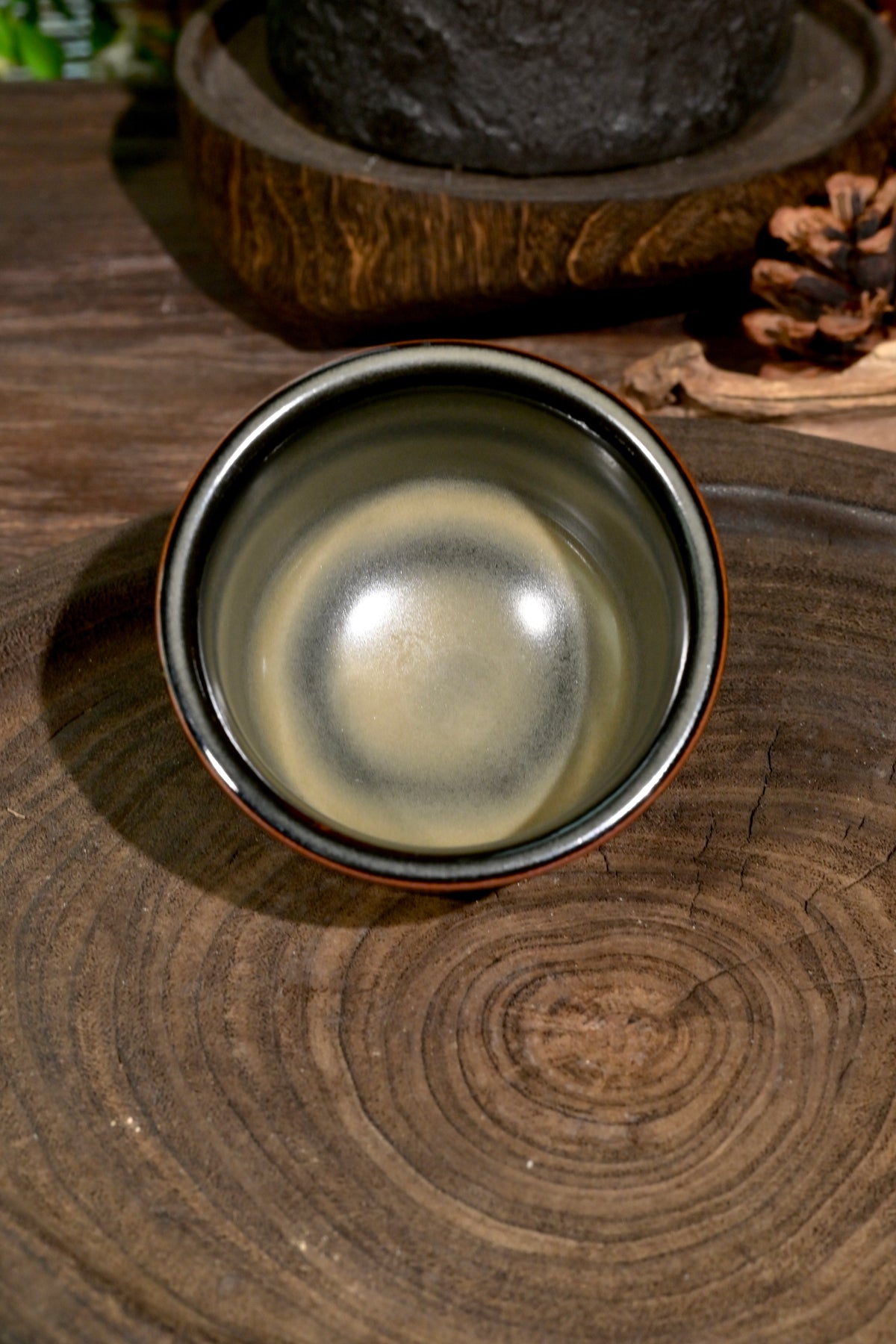 Handcrafted 120ml Chinese celadon master cup displaying tea-dust mineral glaze transmutation
