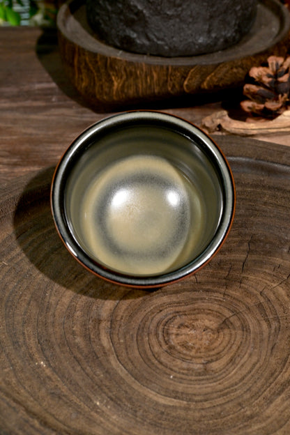 Handcrafted 120ml Chinese celadon master cup displaying tea-dust mineral glaze transmutation