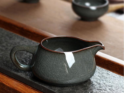 Saanwu Studio fairness cup made from iron-rich clay, finished with luminous celadon glaze and natural cracking.