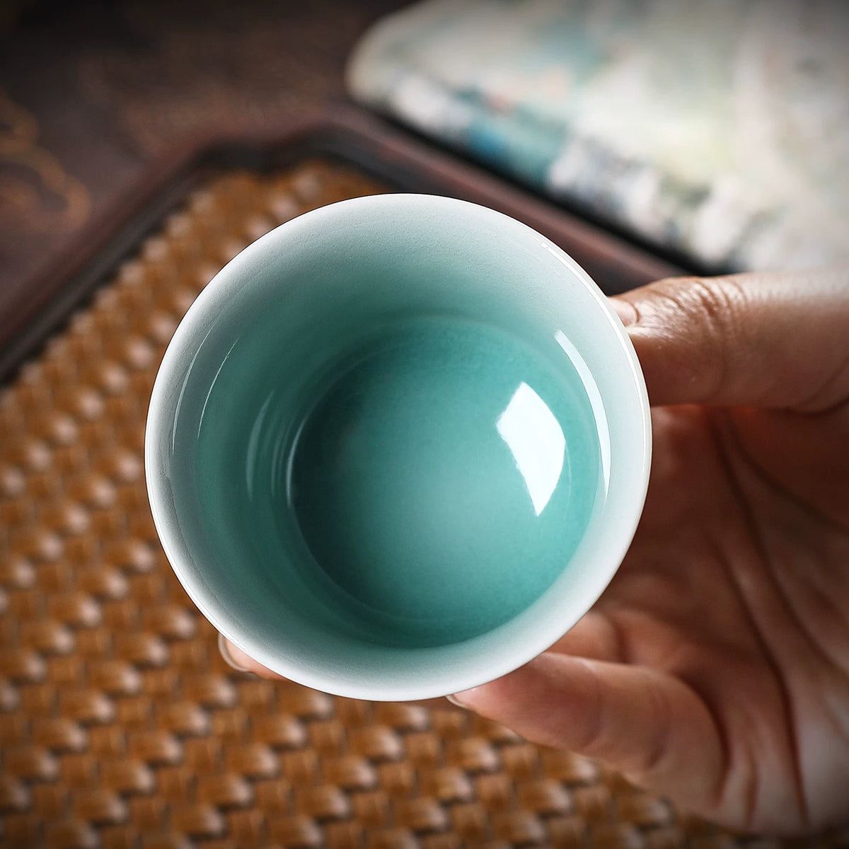 Hand-carved Chinese celadon tea cup with rice-grain pierced floral pattern for Gongfu tea rituals