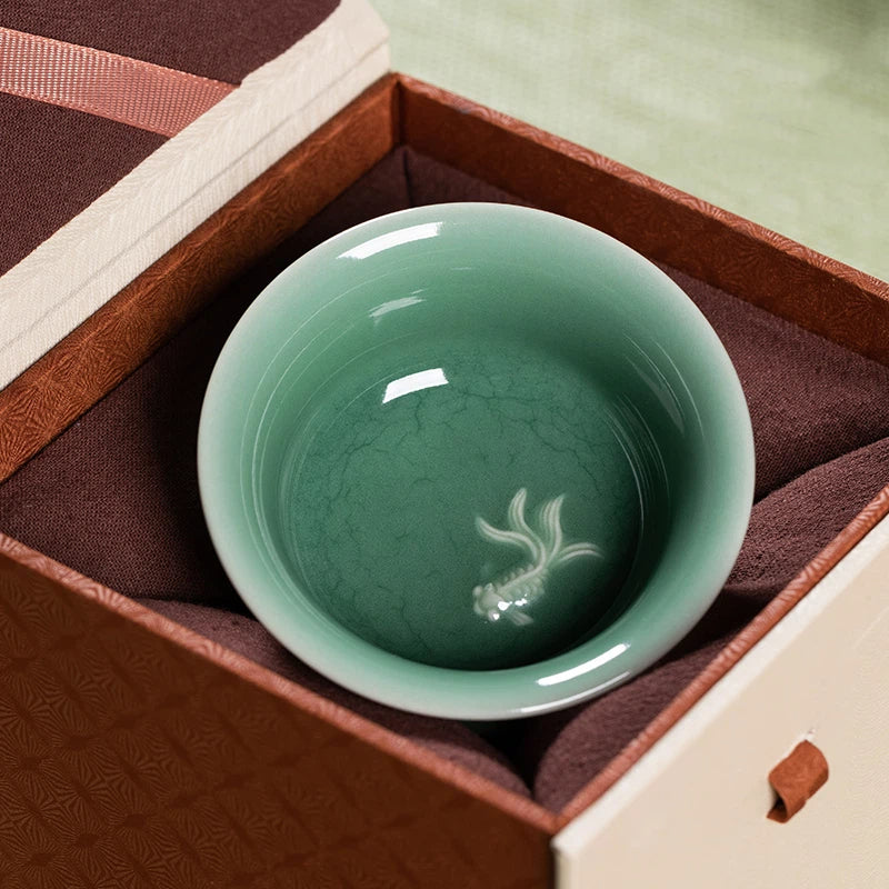 Beautifully Handcrafted Celadon Teacup in Traditional Longquan Style, Decorated with Embossed Koi Fish and Subtle Crackle Glaze for Elegant Texture.