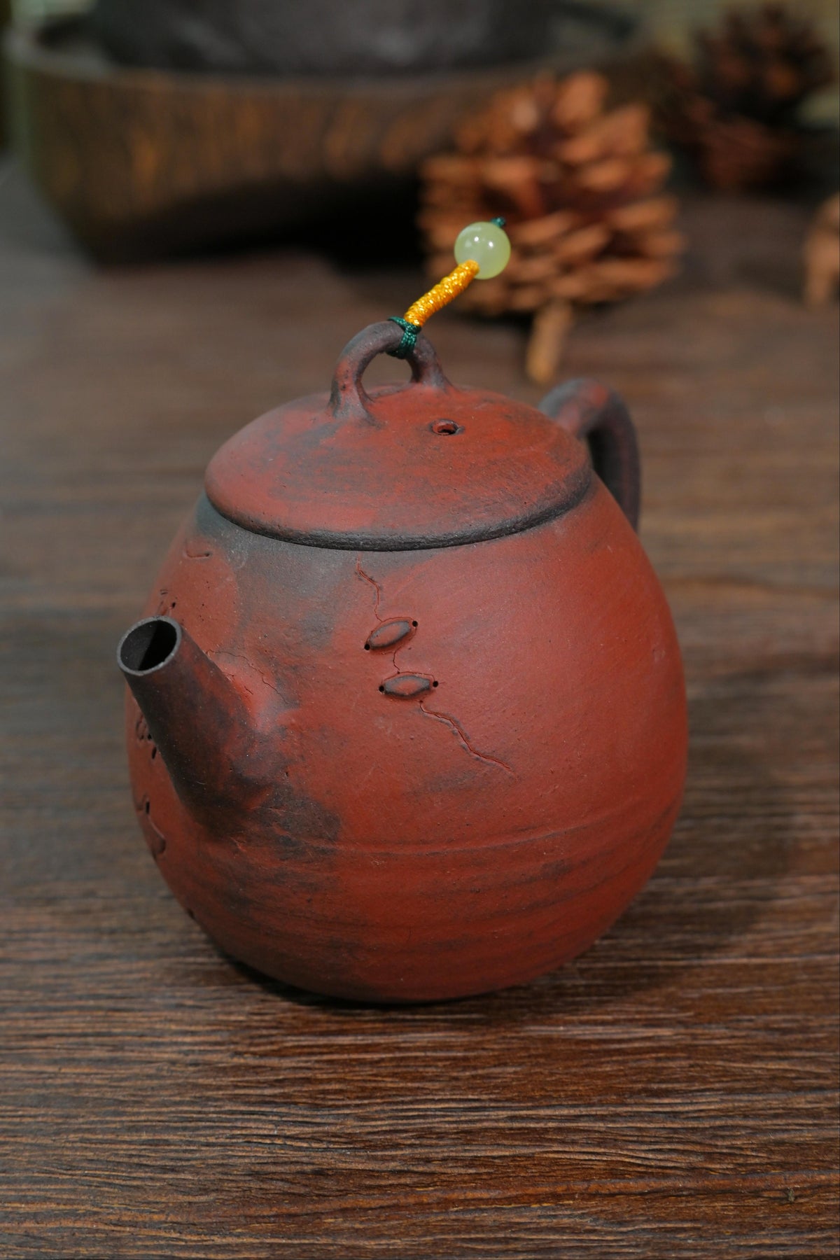 Chashao wood-fired terracotta teapot displaying hand-engraved script and dark charcoal embers on body