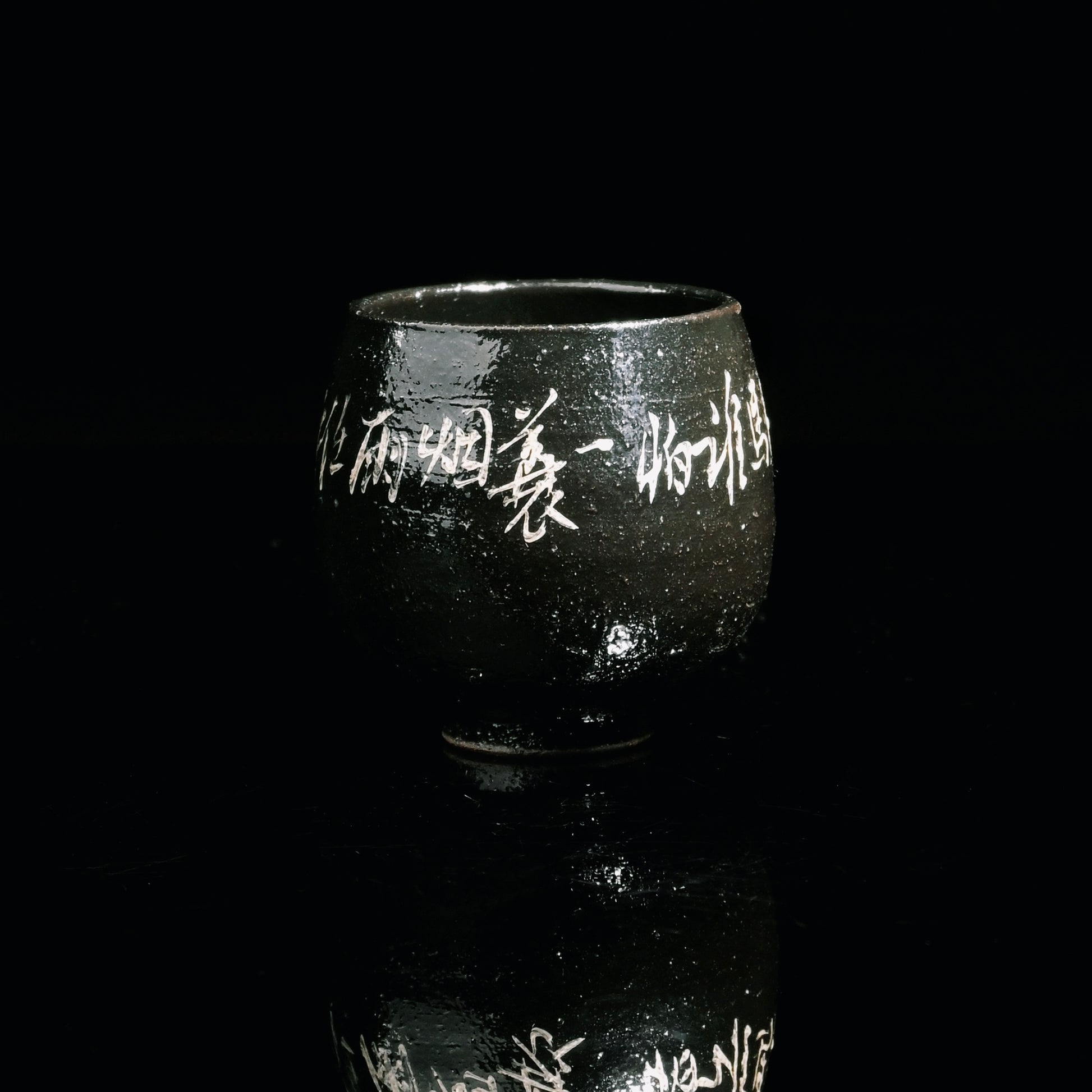 Saanwu Porcelain teacup with shiny black glaze and delicate silver calligraphy design