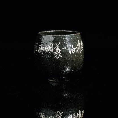 Saanwu Porcelain teacup with shiny black glaze and delicate silver calligraphy design