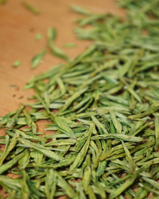 Brewing Shifeng Longjing tea in a glass cup with 85-90°C water to appreciate unfurling leaves