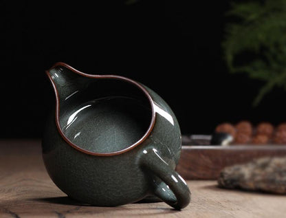 Longquan celadon teacup with iron-gray body and Ge kiln-style glossy crackle glaze.