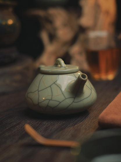 Handcrafted Longquan celadon teapot featuring Ge-style 'golden thread' crackles on creamy glaze, iron-rich clay construction, and engineered pouring angle