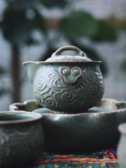 Chinese 'auspicious clouds' dance across this fully handmade zisha tea set, embodying ancient symbolism in functional ceramic art.