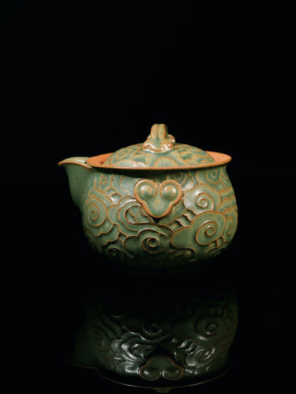 Ergonomic 'hand-grab' style teapot set with textured cloud patterns for perfect grip, made from natural zisha clay that seasons with use.
