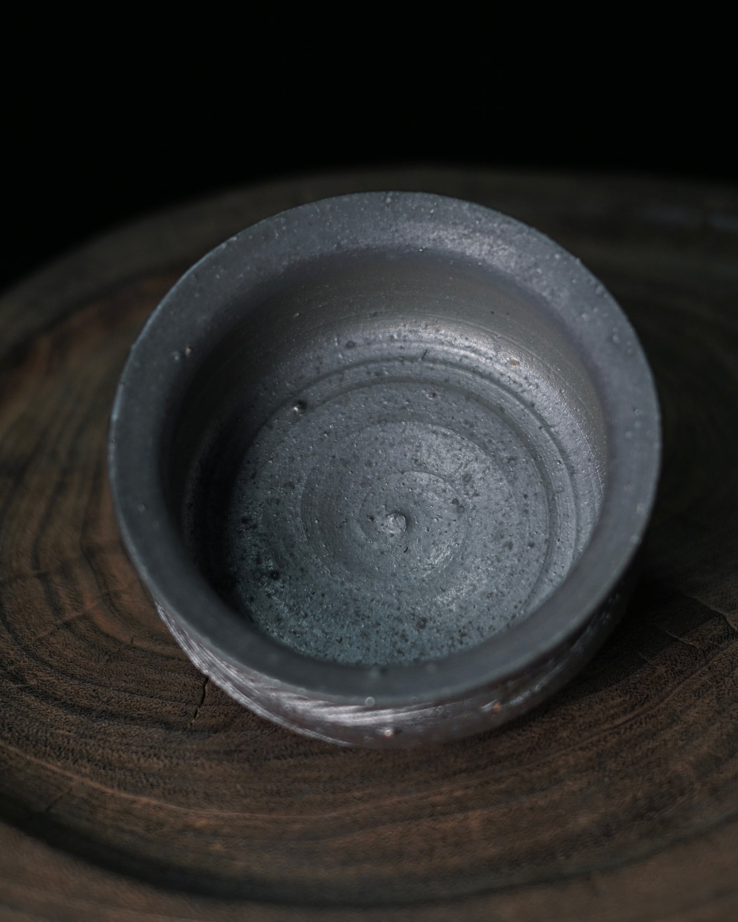 Coarse clay fire mark vessel with color variations from warm amber to cool grey from flame exposure