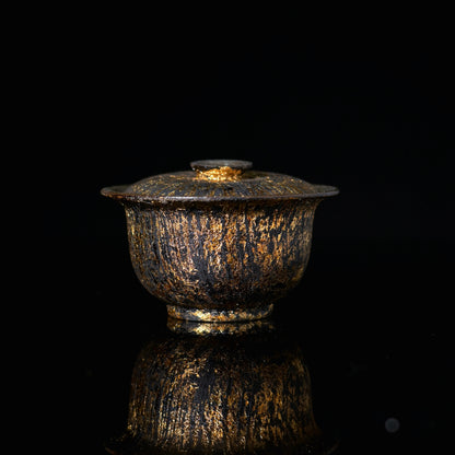 SAANWU handmade coarse clay gaiwan, natural raw lacquer with hand brushed gold streaks, luxury wabi sabi tea ware on black reflective background
