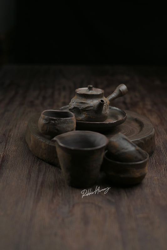 Coarse clay tea ceremony set with handcrafted teapot, fairness cup, and matching cups for traditional brewing