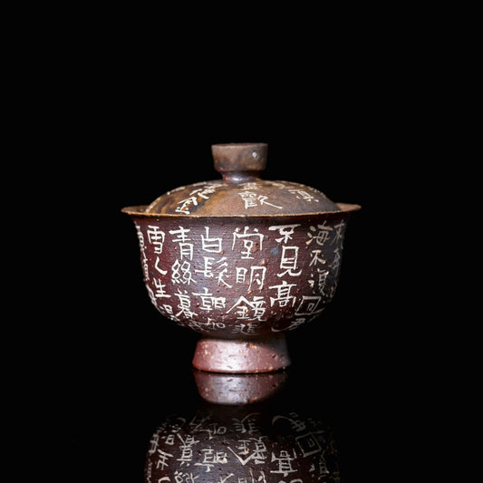 Coarse clay wood-fired gaiwan with unglazed granular surface, ash deposits, and hand-painted calligraphy poem