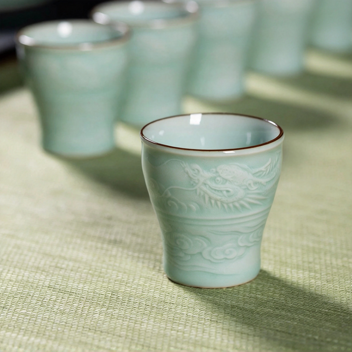Delicate arrangement of the six master tasting cups surrounding the carved fairness pitcher during an elite Gongfu tea gathering