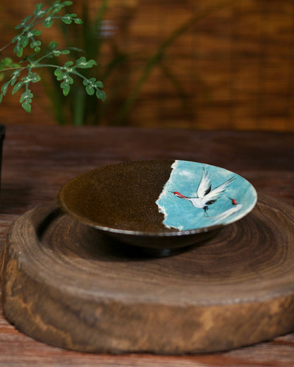 Angled view of the teapot drip tray, highlighting its textured, coarse pottery base and elegant form.