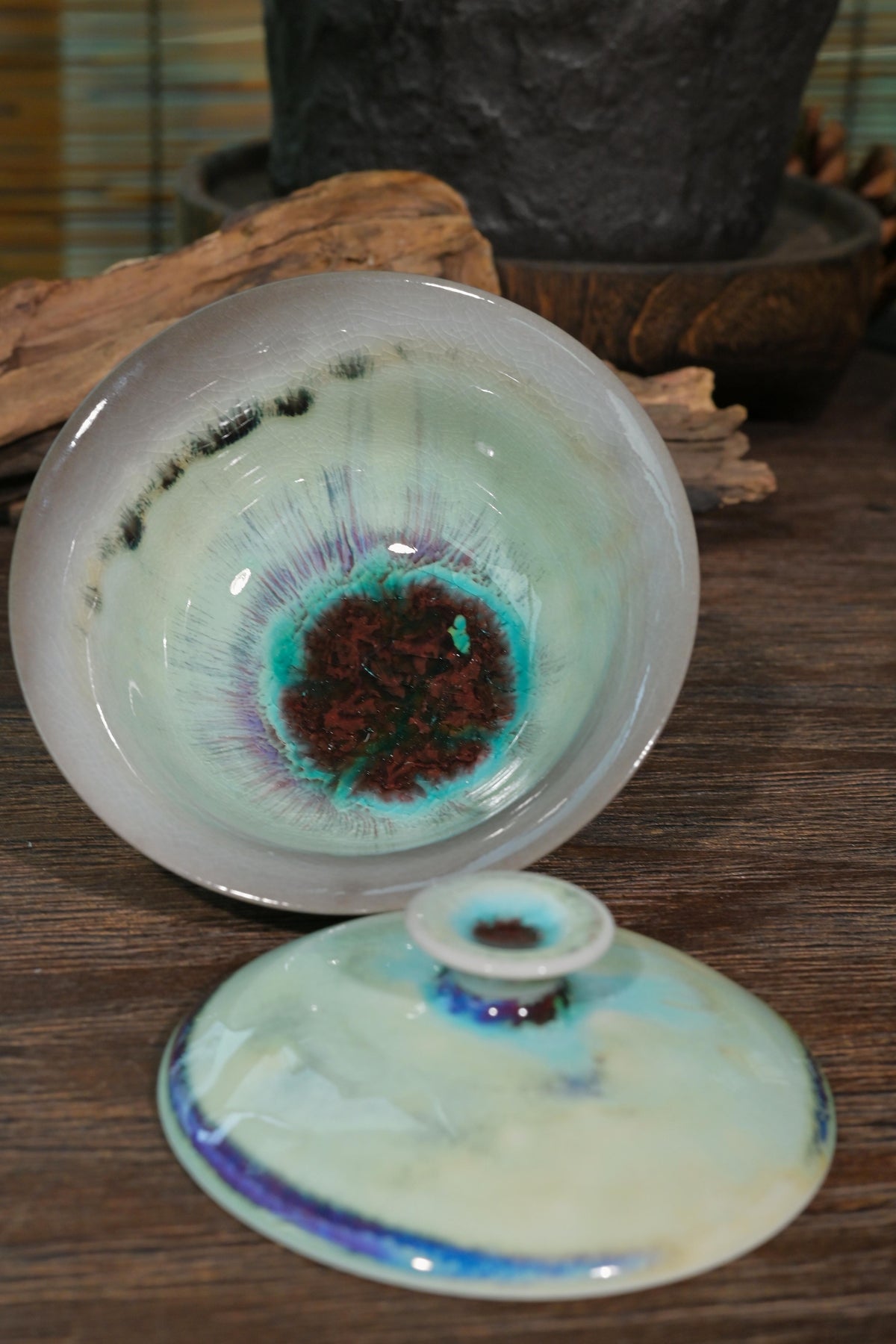 Traditional Chinese wood-fired ingot-shaped gaiwan set against rustic wooden background for Gongfu tea