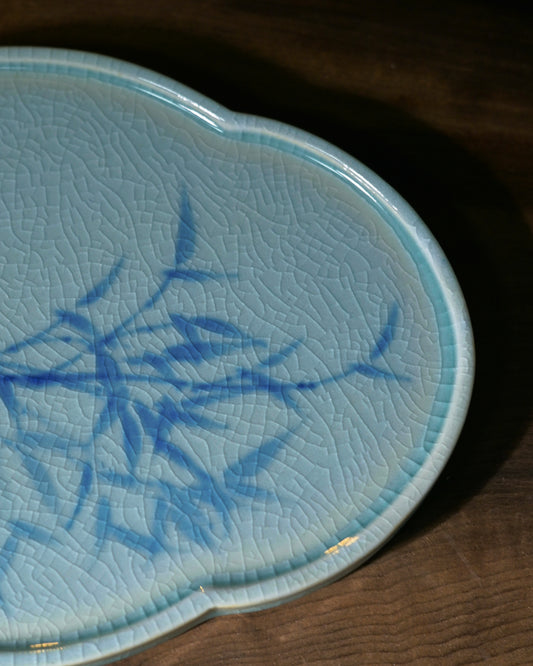 The saucer's bamboo motif displayed alongside elements of plum, orchid, and chrysanthemum — representing the 'Four Gentlemen' virtues: purity, humility, integrity, and grace