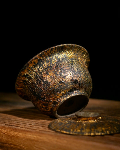 Macro shot of SAANWU raw lacquer gaiwan, vertical hand-drawn gold leaf texture on rough coarse clay body