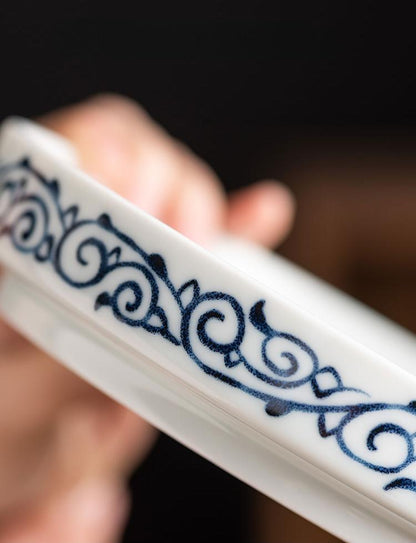 Die blau-weiße Porzellan-Gaiwan mit Scrollmuster und Teetasse