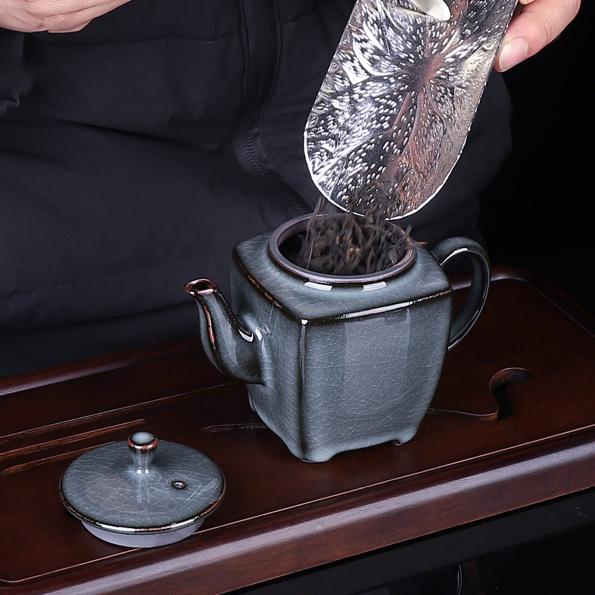 Ge Kiln iron-clay square teapot resting on rustic wooden tray during Gongfu tea ritual