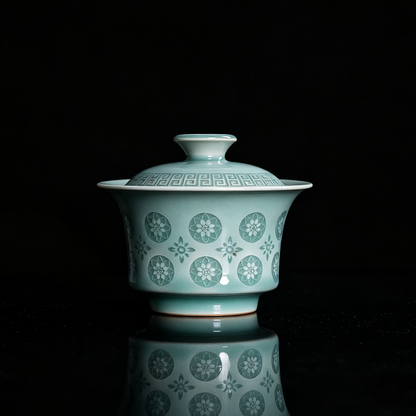 Traditional Chinese Longquan celadon lidded tea bowl with leiwen border lid and glowing pierced flower pattern