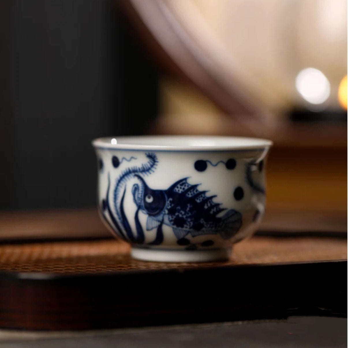 Artistic lifestyle shot of the blue and white fish gaiwan surrounded by tea utensils.