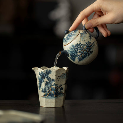 A union of art and utility — the Dragon Egg Teapot features a hand-painted blue-and-white mountain scene, outlined in gold. Its smooth curves and perfect balance make every pour a serene experience.