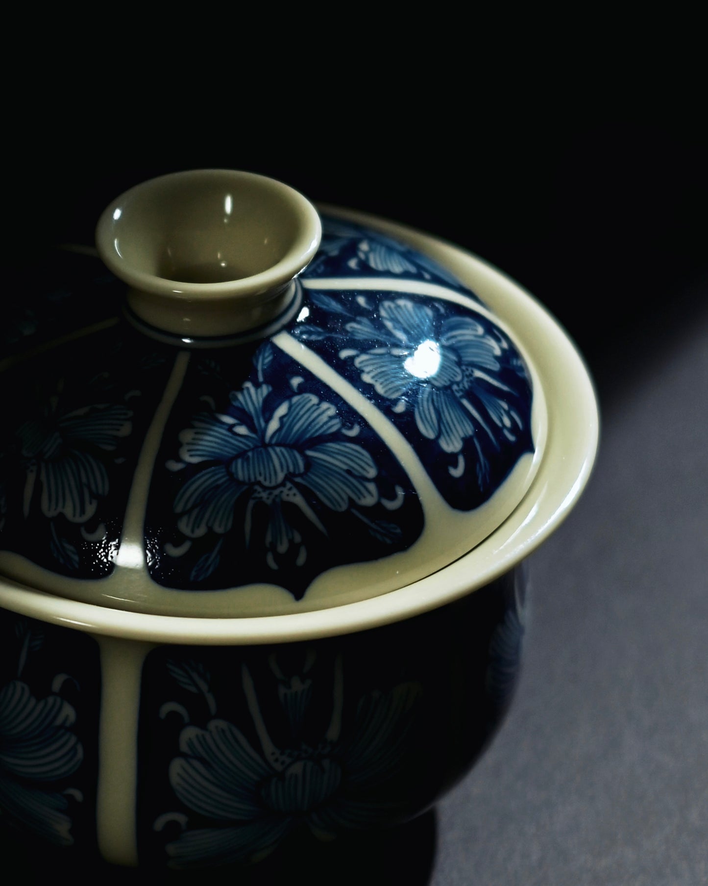 Hand-painted peony tea bowl where cobalt forms continuous background and flowers emerge in white