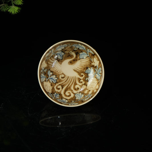 Close-up of genuine gold tracing on a Jingdezhen Phoenix cup showing intricate artisan craftsmanship