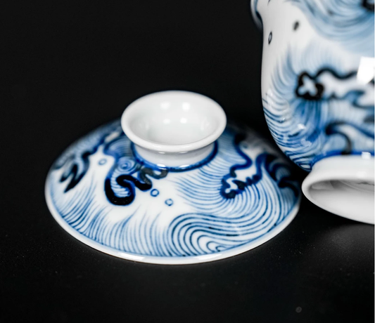 Underglaze hand-painted wave design using traditional cobalt pigment on white porcelain