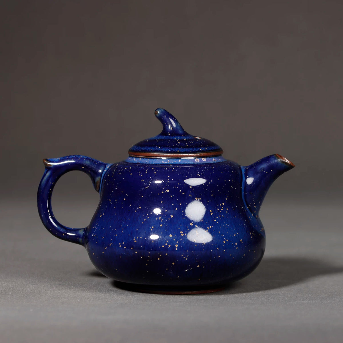 Top-down view of Jun kiln starry blue lid and finial surrounded by crystalline glaze flecks