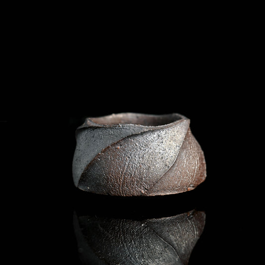 Hand-thrown wabi-sabi tea cup with intentionally uneven rim and raw clay texture