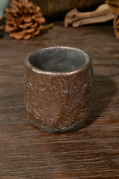 One-of-a-kind wood-fired bark textured ceramic cup displaying dark steel and bronze luster