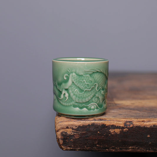 Close-up of sculpted dragon scales and cloud relief on handcrafted Longquan Celadon master cup