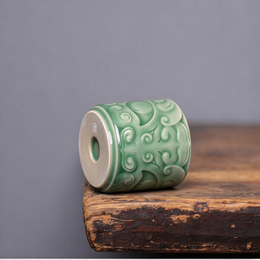 Close-up of sculpted bronze beast mask relief and celadon glaze on handcrafted Longquan Celadon master cup