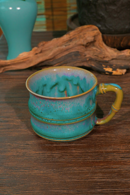 Close-up of Jun Ware 180ml bamboo-joint mug showing rich turquoise glaze melt and warm honey-gold ridge highlights
