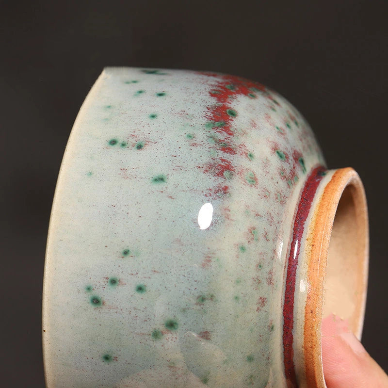 Close-up of Phoenix Tail glaze on a handcrafted Jun Ware teacup, displaying natural kiln-fired color transitions.