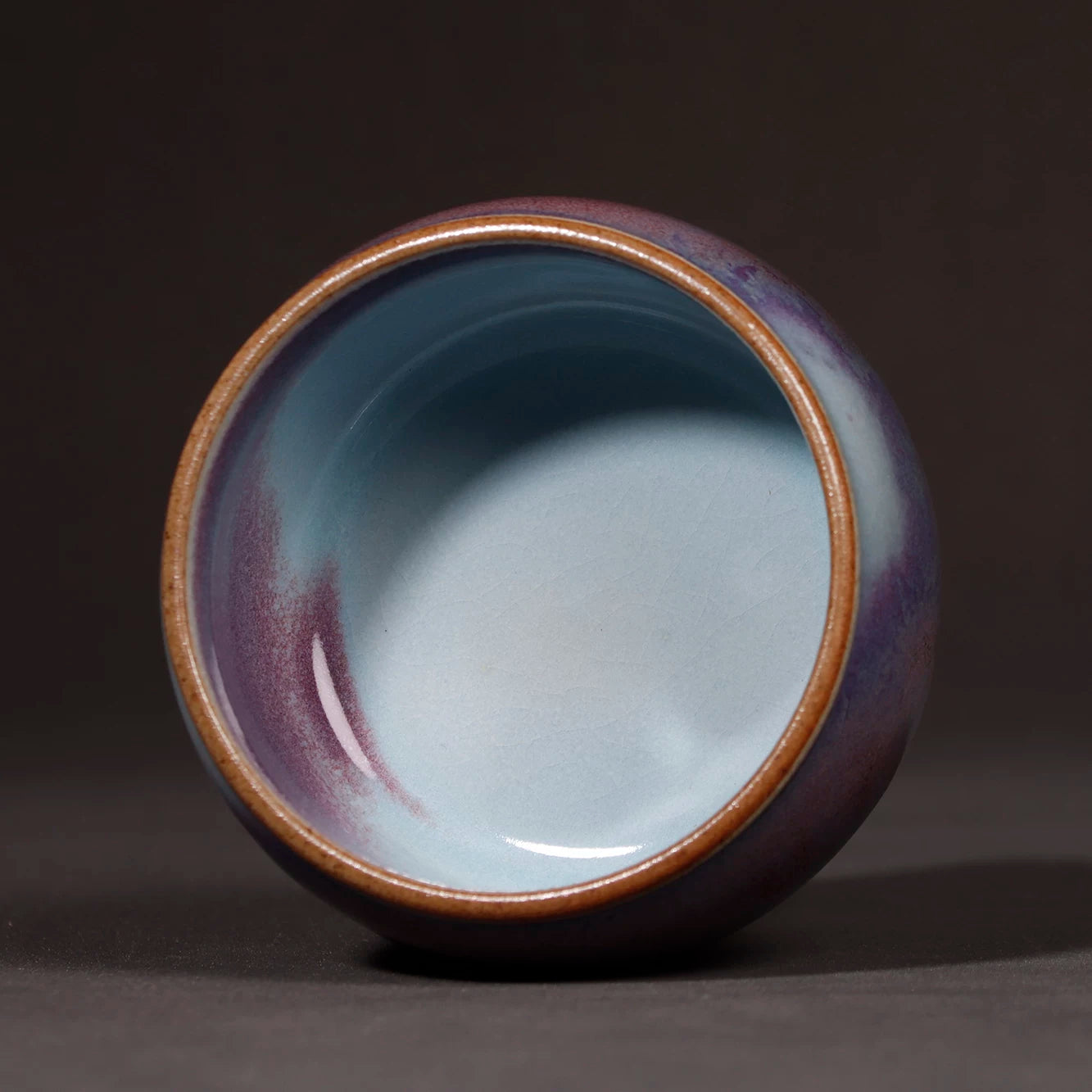 Top-down interior view showing the deep violet glaze flow inside the Jun ware teacup.
