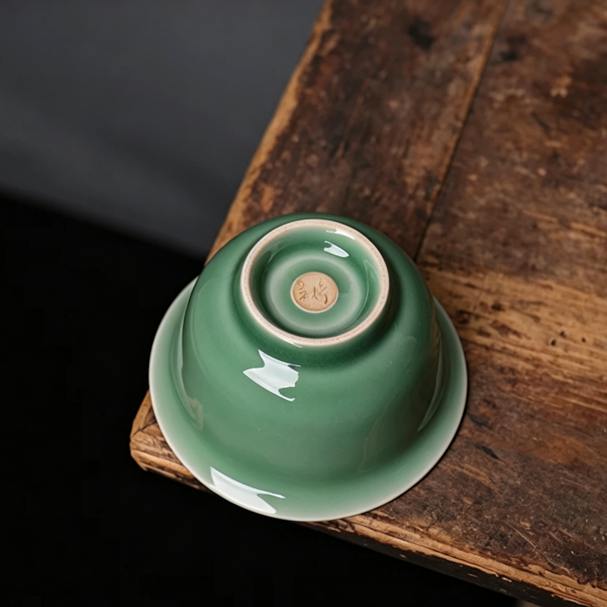 Close-up of plum green celadon gaiwan lid knob and flared rim showing crisp white accent lines