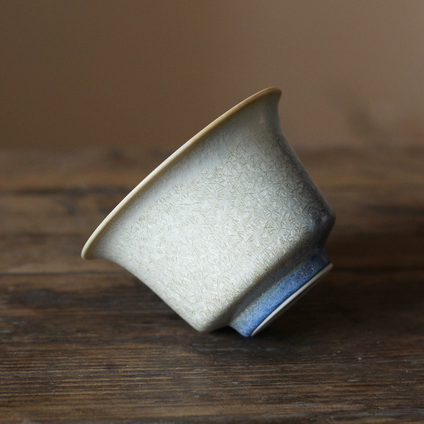 Pine-needle kiln-change porcelain gaiwan from Jingdezhen, displaying organic glaze variations created in high-temperature firing.