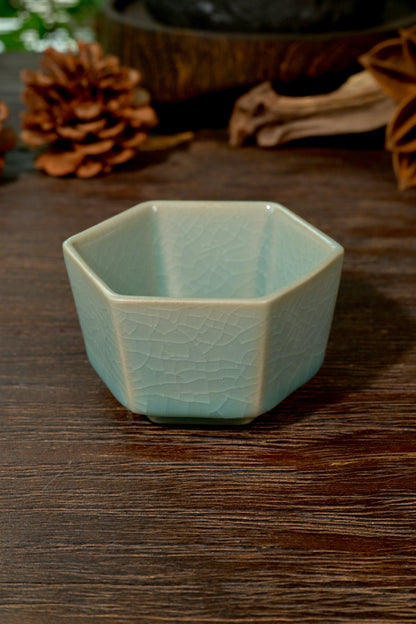 Close-up of hexagonal facets and cicada-wing crackle glaze on handcrafted Ru Ware teacup
