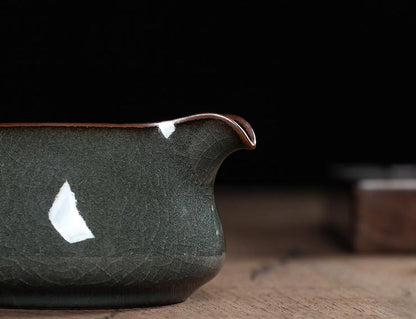 Ge kiln-inspired crackle pattern on a glossy iron-toned Longquan celadon surface.
