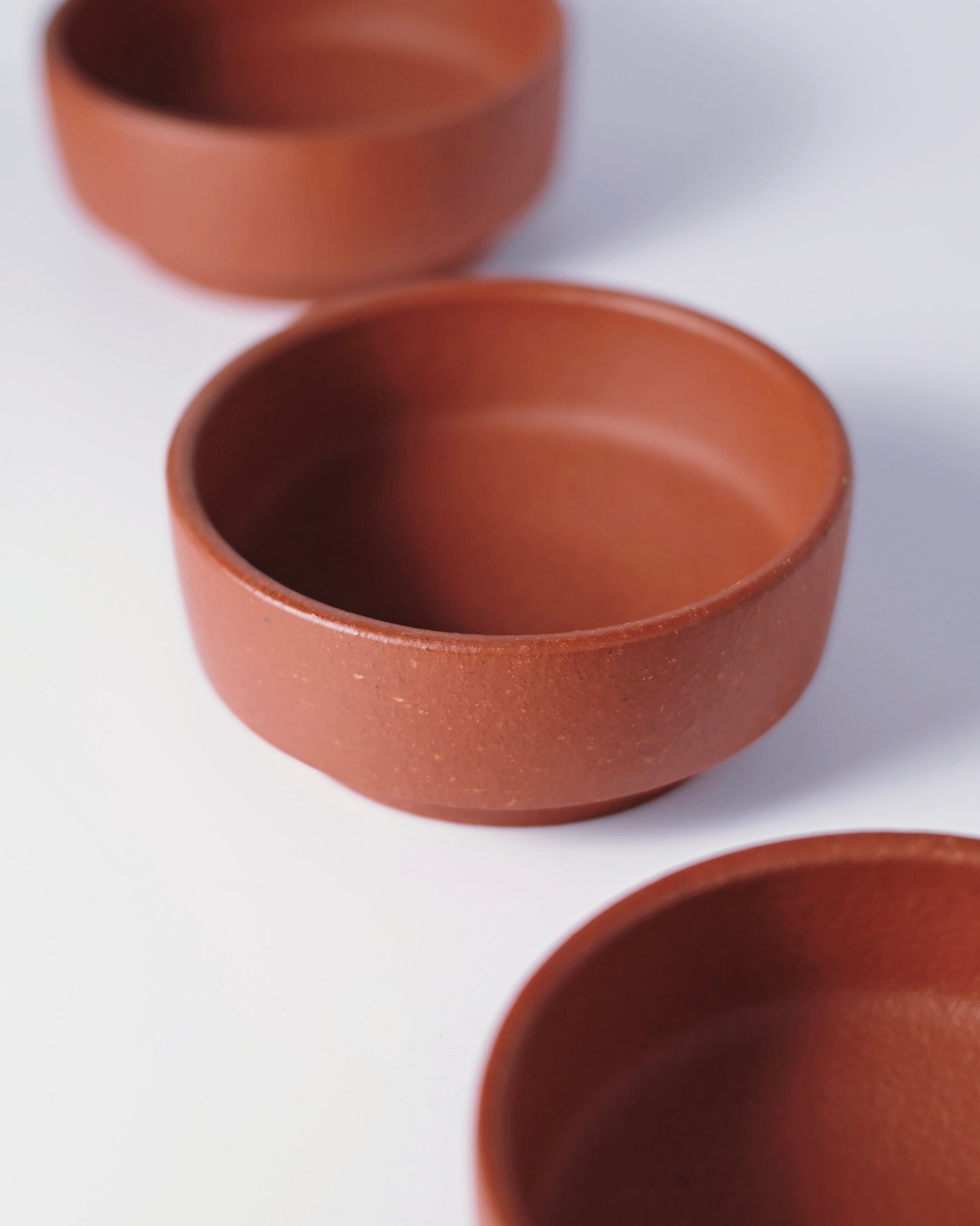 Handmade clay aging process where unglazed surface develops character through repeated tea use