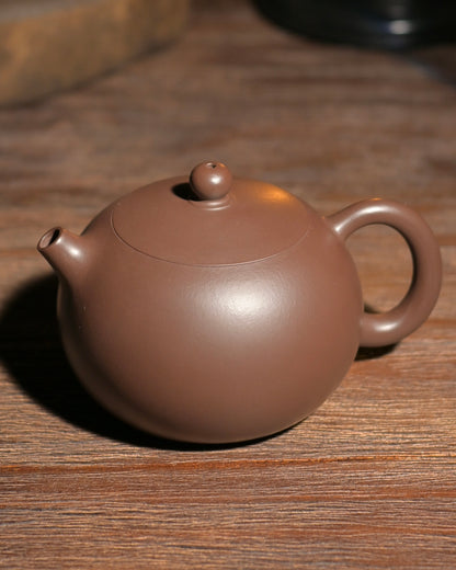 This purple clay Xishi teapot engages all senses - the visual elegance of its form, the tactile pleasure of its polished surface, and the rich aroma it coaxes from oolong and pu'erh teas.